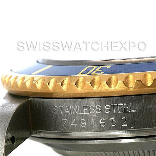 This image shows a close-up of the bezel and case of a Rolex Submariner 16613 Men's Yellow Gold Blue Dial 16613 Men's Yellow Gold Blue Dial, featuring the serial number and stainless steel material engraving.