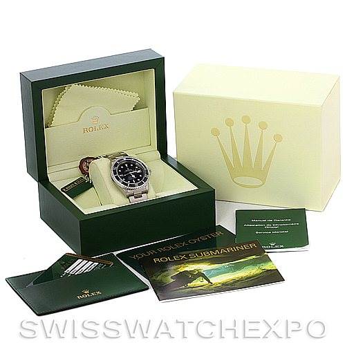 This image shows a Rolex Submariner watch along with its open box, green and yellow packaging, cleaning cloth, and user manuals.