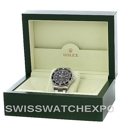 The image shows a Rolex Submariner 16610 Men's Stainless Steel Black Dial 16610 Men's Stainless Steel Black Dial watch from the front, placed inside an open green and beige Rolex box.