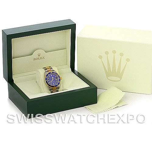 The Rolex Submariner 16613 Men's Steel and Gold (two tone) Blue Dial 16613 Men's Steel and Gold (two tone) Blue Dial watch is displayed at a front angle within its open box, along with an outer box and cleaning cloth.