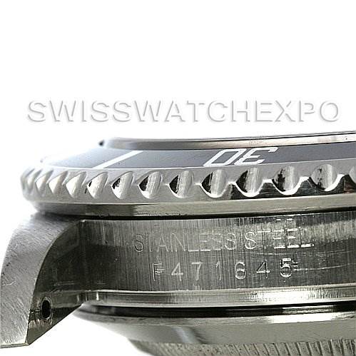 The image shows an angled close-up view of the bezel and case of a Rolex Submariner 16610 Men
s Stainless Steel Black Dial 16610 Men
s Stainless Steel Black Dial watch, with serial numbers and "STAINLESS STEEL" marking visible.