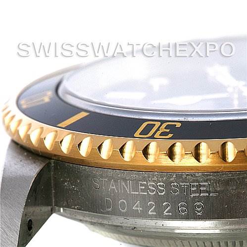 The image shows a close-up angle of the bezel and side case of a Rolex Submariner 16613T Men's Steel and Gold (two tone) Black Dial 16613T Men's Steel and Gold (two tone) Black Dial, featuring its stainless steel and serial number engraving.