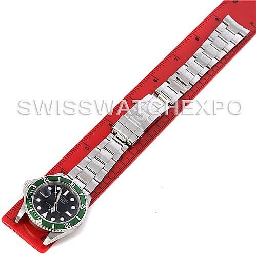 The Rolex Submariner 16610T Men
s Stainless Steel Black Dial 16610T Men
s Stainless Steel Black Dial watch is shown lying flat with its face, bracelet, and clasp visible next to a red ruler.