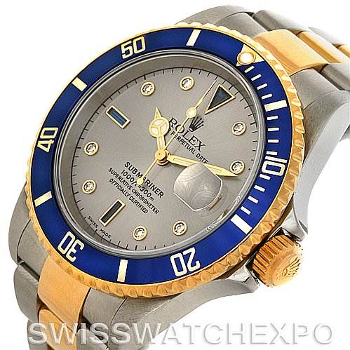The image shows a Rolex Submariner 16613 Men's Steel and Gold (two tone) Grey Dial 16613 Men's Steel and Gold (two tone) Grey Dial watch from an angled view, highlighting the blue bezel, grey dial, crown, and two-tone bracelet.