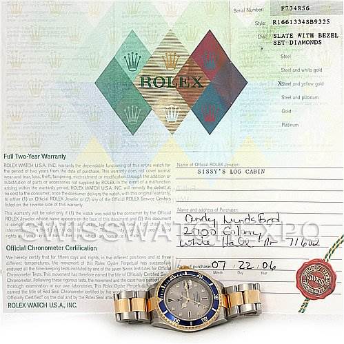 The image shows a Rolex Submariner 16613 Men's Steel and Gold (two tone) Grey Dial 16613 Men's Steel and Gold (two tone) Grey Dial watch placed on top of its warranty card, viewed from the top.