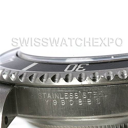 This image shows a close-up of the side of a Rolex Submariner 14060M Men's Stainless Steel Black Dial 14060M Men's Stainless Steel Black Dial watch, highlighting the bezel and part of the case with the serial number engraved.