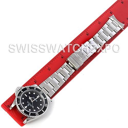 The Rolex Submariner 14060M Men's Stainless Steel Black Dial 14060M Men's Stainless Steel Black Dial watch is displayed flat on a red ruler, showing the full length of its stainless steel bracelet and face.