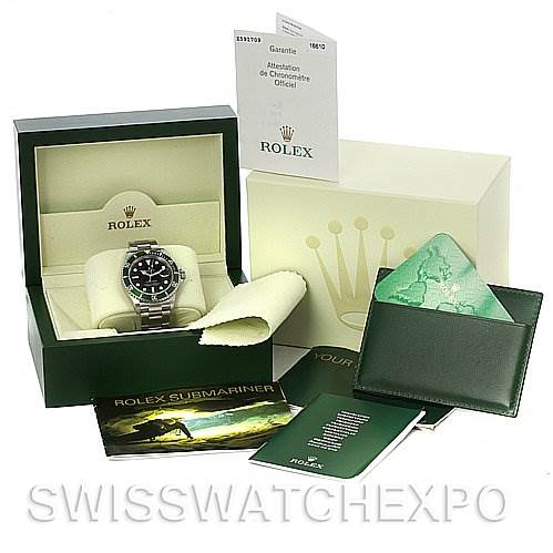 The image shows a Rolex Submariner 16610T Men's Stainless Steel Black Dial 16610T Men's Stainless Steel Black Dial watch in its box, with accessories including manuals, warranty card, and a green wallet.