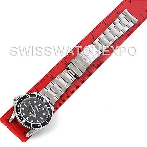 The image shows a top-down view of a Rolex Submariner 16610 Men's Stainless Steel Black Dial 16610 Men's Stainless Steel Black Dial watch placed against a red ruler for scale.