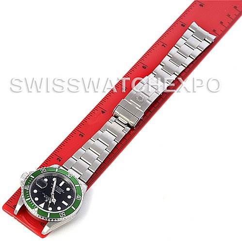 This image shows a top view of a Rolex Submariner 16610LV Men's Stainless Steel Black Dial 16610LV Men's Stainless Steel Black Dial, including its bracelet and partially opened clasp, placed on a red ruler.