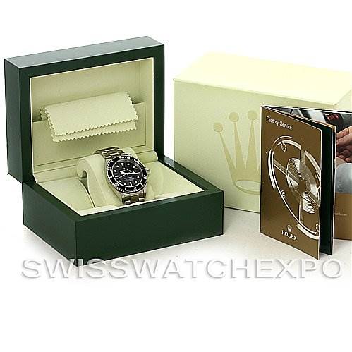 The image shows a Rolex Submariner 16610 Men's Stainless Steel Black Dial 16610 Men's Stainless Steel Black Dial watch inside its open box, with accompanying booklets and accessories beside it.