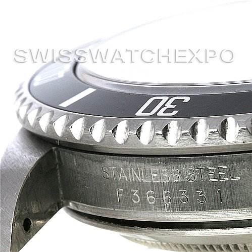 The image shows a close-up of the bezel and side of a Rolex Submariner 16610 Men's Stainless Steel Black Dial 16610 Men's Stainless Steel Black Dial watch case, including part of the model number engraved.