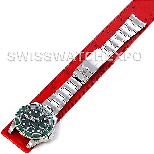 This image shows a Rolex Submariner 116610LV Men's Stainless Steel Green Dial 116610LV Men's Stainless Steel Green Dial model laid flat next to a red ruler, displaying both the watch face and bracelet.