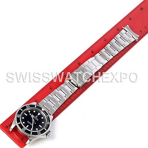 The image shows a top-down view of a Rolex Submariner 14060M Men's Stainless Steel Black Dial 14060M Men's Stainless Steel Black Dial watch placed next to a red ruler.