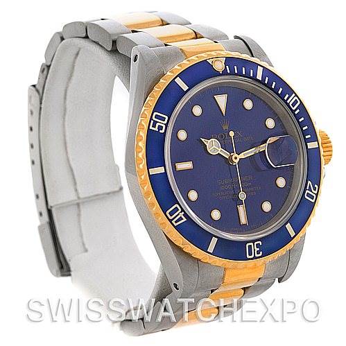 The image shows a Rolex Submariner 16803 Men's Steel and Gold (two tone) Blue Dial 16803 Men's Steel and Gold (two tone) Blue Dial watch from a three-quarter angle, highlighting its blue dial, bezel, and two-tone band.
