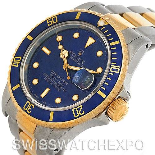 The image shows a Rolex Submariner 16803 Men's Steel and Gold (two tone) Blue Dial 16803 Men's Steel and Gold (two tone) Blue Dial watch at an angle focusing on the dial, bezel, and part of the bracelet.