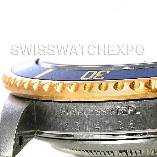 The image shows a close-up of the bezel, part of the case, and the serial number engraving on a Rolex Submariner 16803 Men's Steel and Gold (two tone) Blue Dial 16803 Men's Steel and Gold (two tone) Blue Dial watch.
