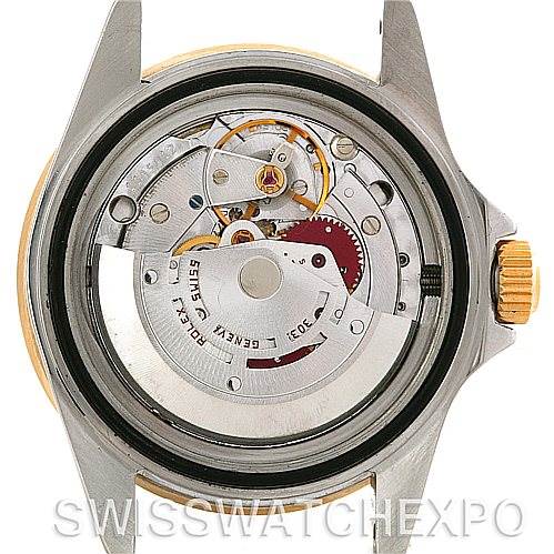 The image shows the internal mechanism of a Rolex Submariner 16803 Men's Steel and Gold (two tone) Blue Dial 16803 Men's Steel and Gold (two tone) Blue Dial watch from a rear angle, displaying its intricate movement.