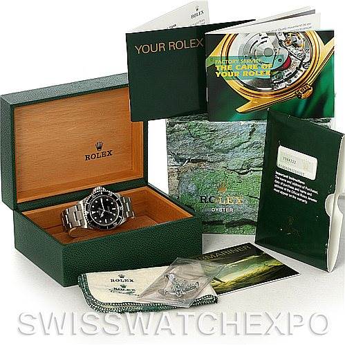 This image shows the Rolex Submariner 14060M Men's Stainless Steel Black Dial 14060M Men's Stainless Steel Black Dial watch at an angle inside its branded green box, along with manuals, booklets, and additional accessories.