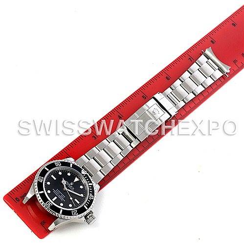 The image shows a full view of a Rolex Submariner 14060M Men's Stainless Steel Black Dial 14060M Men's Stainless Steel Black Dial watch laid flat next to a red ruler for measurement.