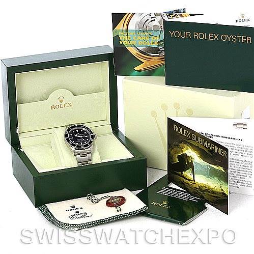 The image shows a Rolex Submariner 16610 Men's Stainless Steel Black Dial 16610 Men's Stainless Steel Black Dial watch with its box, various booklets, a tag, and a cleaning cloth.