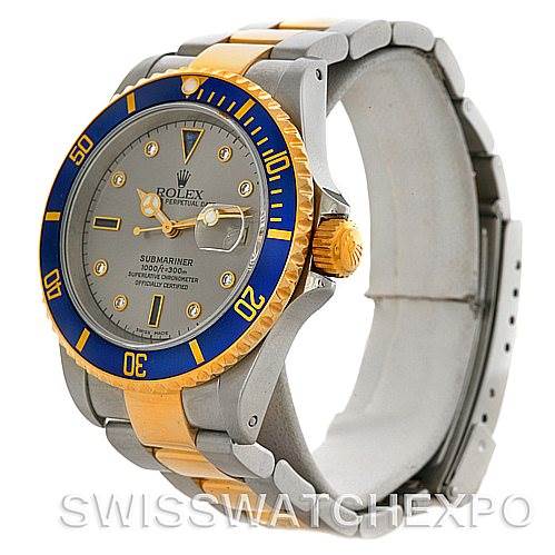 The image shows a Rolex Submariner 16613 Men's Steel and Gold (two tone) Grey Dial 16613 Men's Steel and Gold (two tone) Grey Dial watch viewed from the front-left angle, highlighting its grey and gold case and blue bezel.