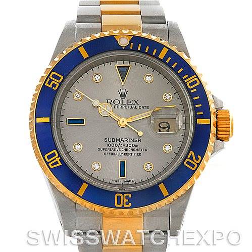 The image shows a Rolex Submariner 16613 Men's Steel and Gold (two tone) Grey Dial 16613 Men's Steel and Gold (two tone) Grey Dial watch from the front, highlighting its grey dial, blue and gold bezel, and two-tone bracelet.