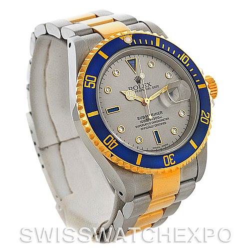 This image shows a Rolex Submariner 16613 Men's Steel and Gold (two tone) Grey Dial 16613 Men's Steel and Gold (two tone) Grey Dial watch at a three-quarter angle, highlighting its gray and gold bracelet, blue bezel, and dial face.