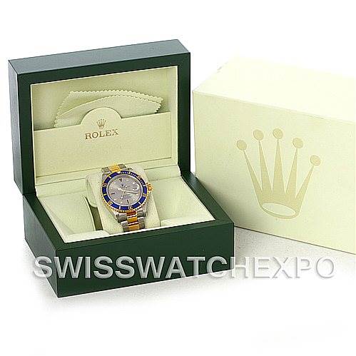 The image shows a Rolex Submariner 16613 Men's Steel and Gold (two tone) Grey Dial 16613 Men's Steel and Gold (two tone) Grey Dial watch in a green display box, including the outer cream-colored box with the Rolex logo.