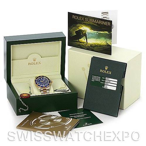 The image shows a Rolex Submariner 16613 Men's Steel and Gold (two tone) Blue Dial 16613 Men's Steel and Gold (two tone) Blue Dial watch at an angled view in its open box, with accompanying booklets and accessories displayed around it.