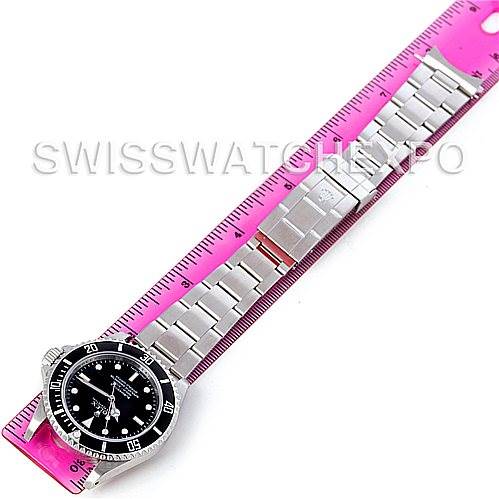 The image shows a Rolex Submariner 14060M Men's Stainless Steel Black Dial 14060M Men's Stainless Steel Black Dial watch laid flat with a ruler, displaying the face and strap.