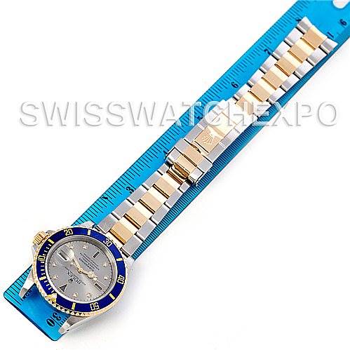 This image shows a top-down view of a Rolex Submariner 16613 Men's Steel and Gold (two tone) Grey Dial 16613 Men's Steel and Gold (two tone) Grey Dial watch, including its face, bezel, and metal bracelet, against a ruler background.