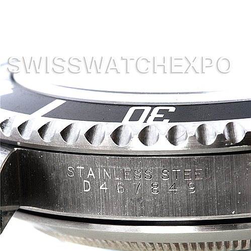 The image shows a close-up of the side of the bezel and case of a Tank Solo model by Cartier, with part of the serial number and "stainless steel" visible.
