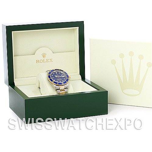 The image shows a Rolex Submariner 16613 Men's Steel and Gold (two tone) Blue Dial 16613 Men's Steel and Gold (two tone) Blue Dial watch at a front angle, displayed in an open green and beige Rolex box with the logo visible.