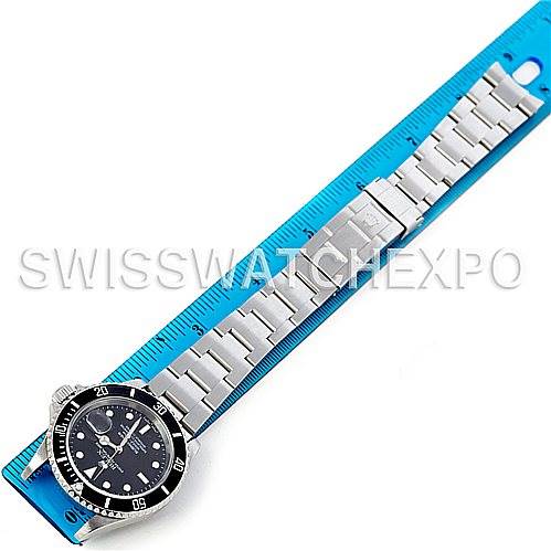 The image shows a full view of the Rolex Submariner 16610 Men's Stainless Steel Black Dial 16610 Men's Stainless Steel Black Dial watch laid flat against a measuring ruler, displaying the entire bracelet and watch face.