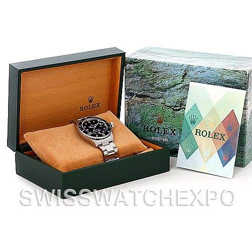 The image shows a Rolex Submariner 16610 Men's Stainless Steel Black Dial 16610 Men's Stainless Steel Black Dial watch in a green display box with a cushion, alongside its packaging and a booklet.