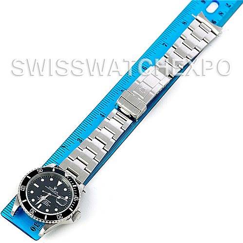 The image shows a top-down view of a Rolex Submariner 16610 Men's Stainless Steel Black Dial 16610 Men's Stainless Steel Black Dial watch with its full metal bracelet next to a blue ruler.