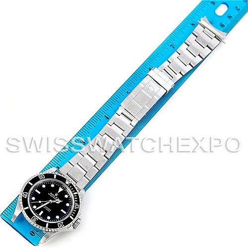 A Rolex Submariner 14060 Men
s Stainless Steel Black Dial 14060 Men
s Stainless Steel Black Dial watch is shown from a top view, extended along a blue measuring ruler.