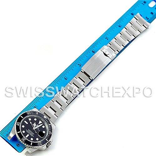 The image shows the entire Rolex Submariner 116610LN Men's Stainless Steel Black Dial 116610LN Men's Stainless Steel Black Dial watch laid flat alongside a blue ruler for scale.