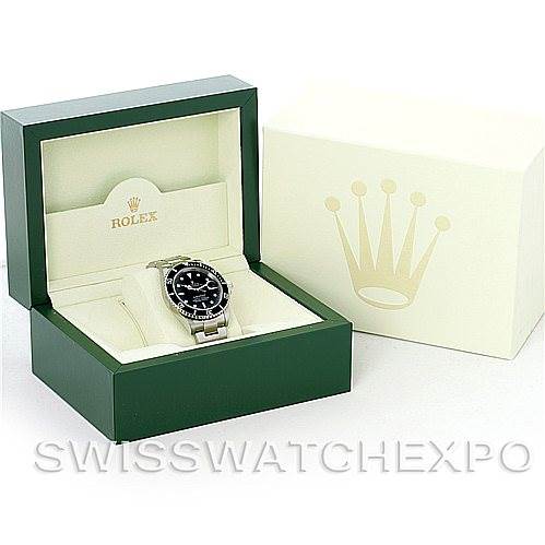 This image shows a Rolex Submariner 16610 Men's Stainless Steel Black Dial 16610 Men's Stainless Steel Black Dial watch placed inside its open green and cream-colored box, with the outer box beside it.