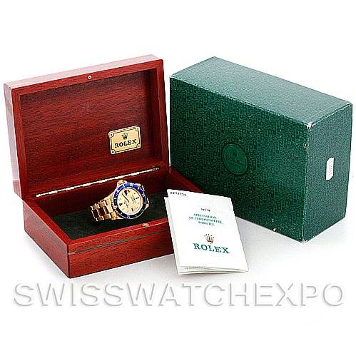 The image shows a Rolex Submariner 16618 Men's Yellow Gold Champagne Dial 16618 Men's Yellow Gold Champagne Dial watch displayed in an open wooden box, accompanied by a Rolex certificate and green outer box.