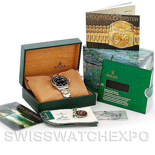 The image shows a Rolex Submariner 16613 Men's Steel and Gold (two tone) Black Dial 16613 Men's Steel and Gold (two tone) Black Dial watch at an angle inside its box, with accompanying booklets, a warranty card, and accessories.