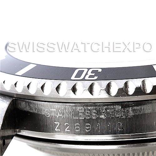 The image shows a close-up side view of a Rolex Submariner 16610 Men's Stainless Steel Black Dial 16610 Men's Stainless Steel Black Dial's bezel, crown guard, and engraved serial number on the case.