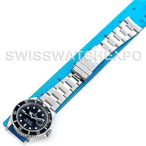 This image shows a top-down view of a Rolex Submariner 16610 Men's Stainless Steel Black Dial 16610 Men's Stainless Steel Black Dial watch, with a blue ruler next to it for scale.