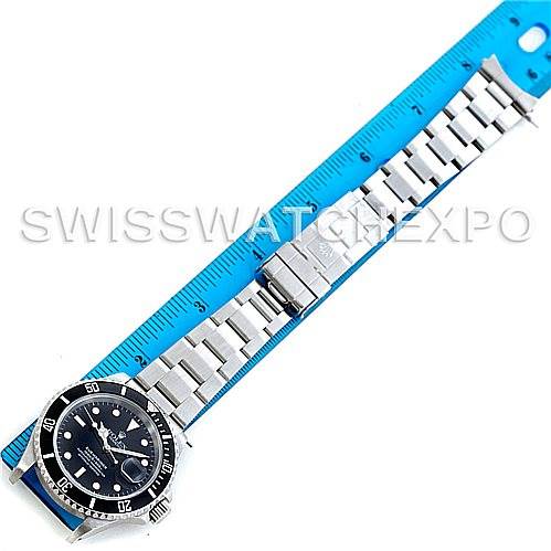 The image shows a full overhead view of a Rolex Submariner 16610 Men's Stainless Steel Black Dial 16610 Men's Stainless Steel Black Dial watch alongside a blue ruler for scale.