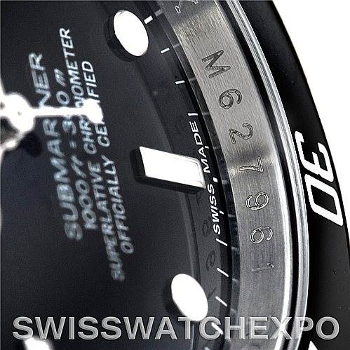 Close-up view of a Rolex Submariner 16610 Men
s Stainless Steel Black Dial 16610 Men
s Stainless Steel Black Dial dial and bezel, showing the hour markers, part of the bezel with numbers, and the brand inscriptions.