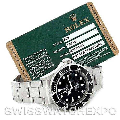 The image shows a Rolex Submariner 16610 Men
s Stainless Steel Black Dial 16610 Men
s Stainless Steel Black Dial watch lying flat with its face visible, alongside a certification card with Rolex branding.