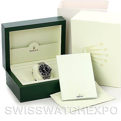 The image shows a Rolex Submariner 16610 Men
s Stainless Steel Black Dial 16610 Men
s Stainless Steel Black Dial watch, with its open green box, packaging, and accompanying booklets.