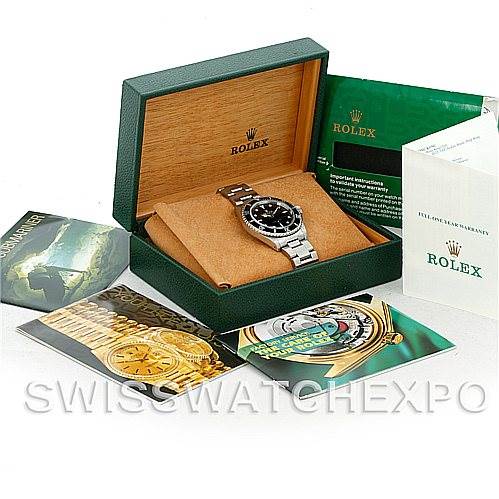 The image shows a Rolex Submariner 14060 Men
s Stainless Steel Black Dial 14060 Men
s Stainless Steel Black Dial watch inside its box, accompanied by manuals and product booklets.