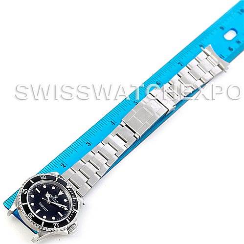 This image shows a Rolex Submariner 14060 Men
s Stainless Steel Black Dial 14060 Men
s Stainless Steel Black Dial watch laid flat, highlighting the face, bezel, and stainless steel bracelet with a ruler alongside for scale.